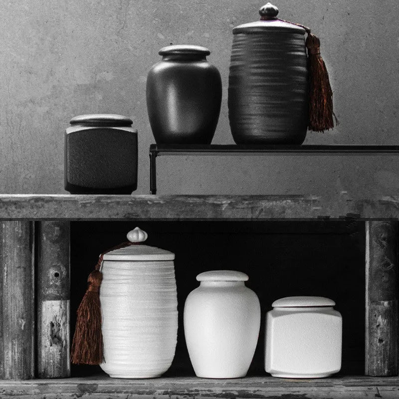 Collection of black and white ceramic pet urns and dog urns in various shapes and sizes, part of the Everpaw Signature Urn Collection for pet cremation ashes.